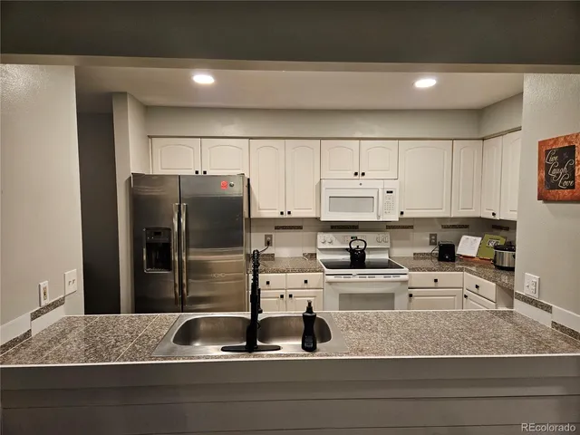 a kitchen with a refrigerator a sink and cabinets