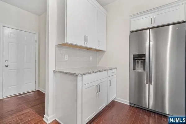 a kitchen with stainless steel appliances a refrigerator and wooden floor