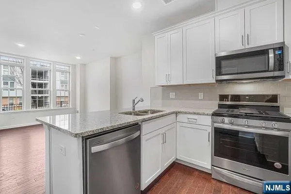 a kitchen with stainless steel appliances granite countertop a stove and a microwave