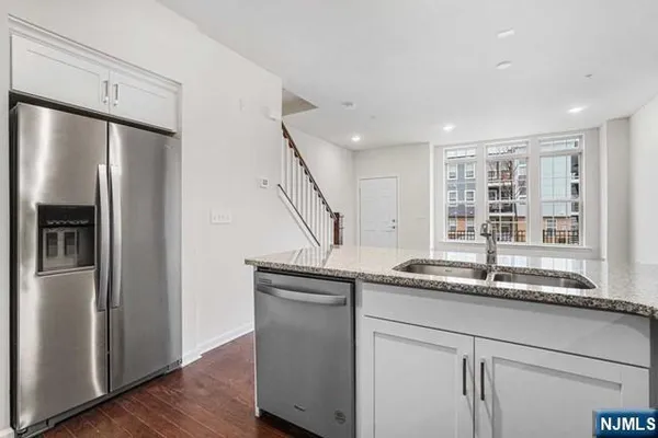 a kitchen with stainless steel appliances granite countertop a refrigerator and a sink