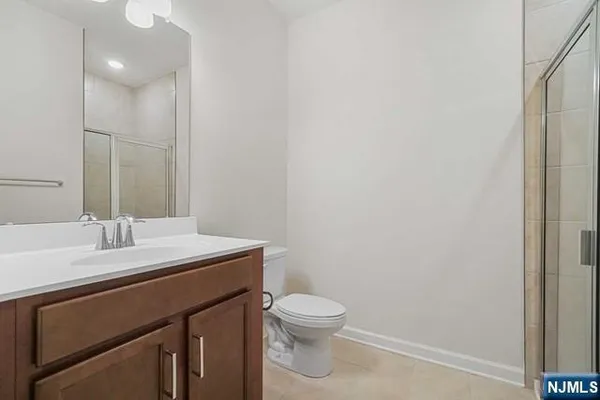 a bathroom with a granite countertop sink a toilet and a mirror