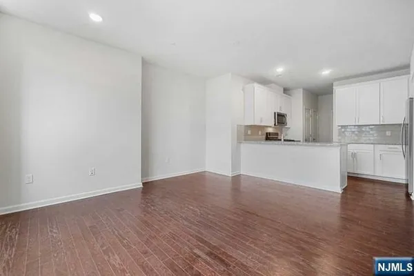 a view of a kitchen with wooden floor and a sink