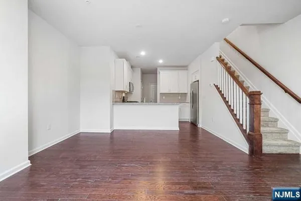 a view of a kitchen with wooden floor and electronic appliances