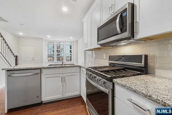 a kitchen with stainless steel appliances granite countertop a stove and a microwave