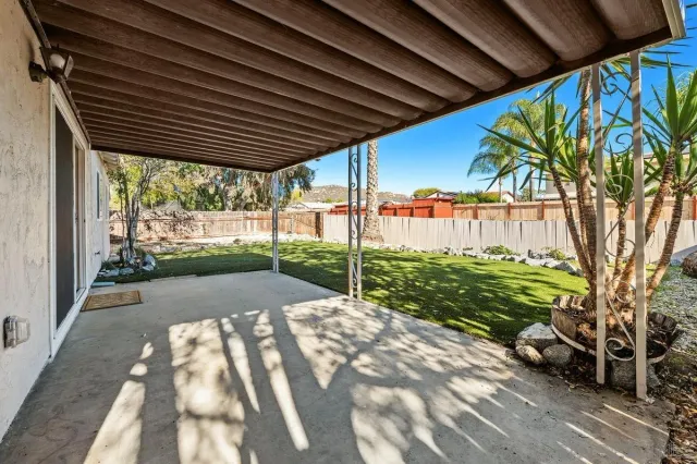 a view of a backyard with table and chairs under an umbrella