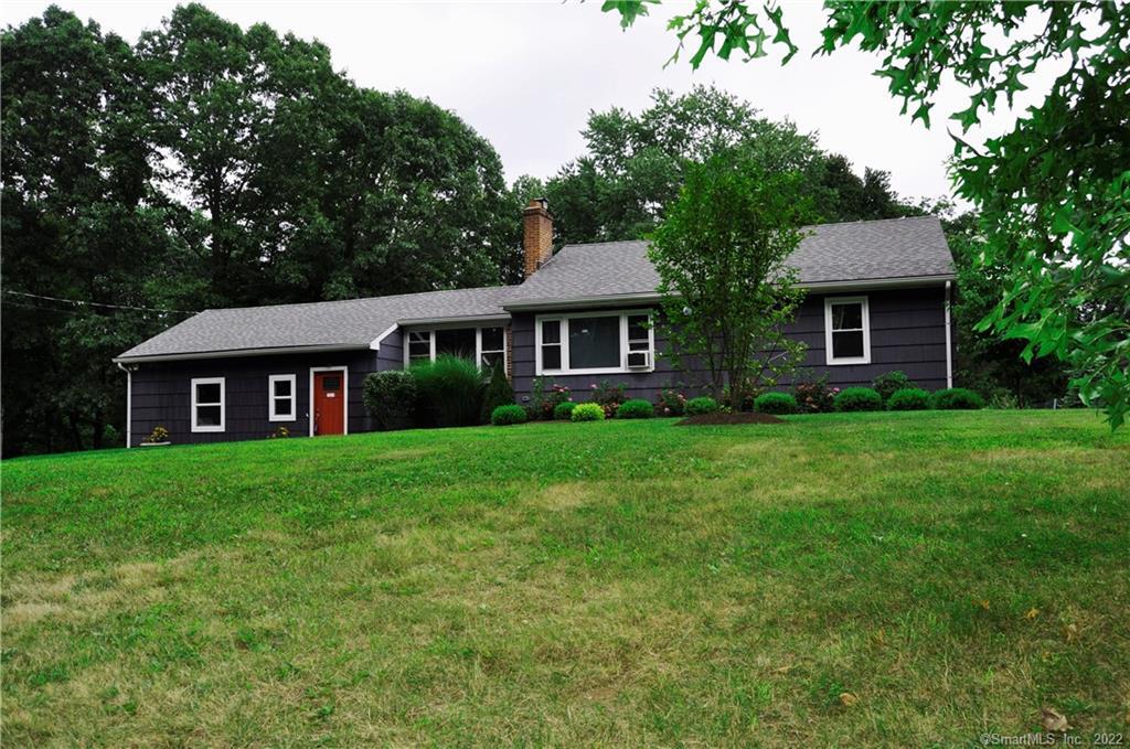 a view of a yard in front of a house with large trees