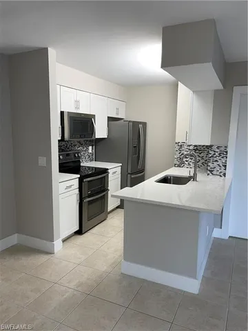 a kitchen with stainless steel appliances a refrigerator and a stove top oven