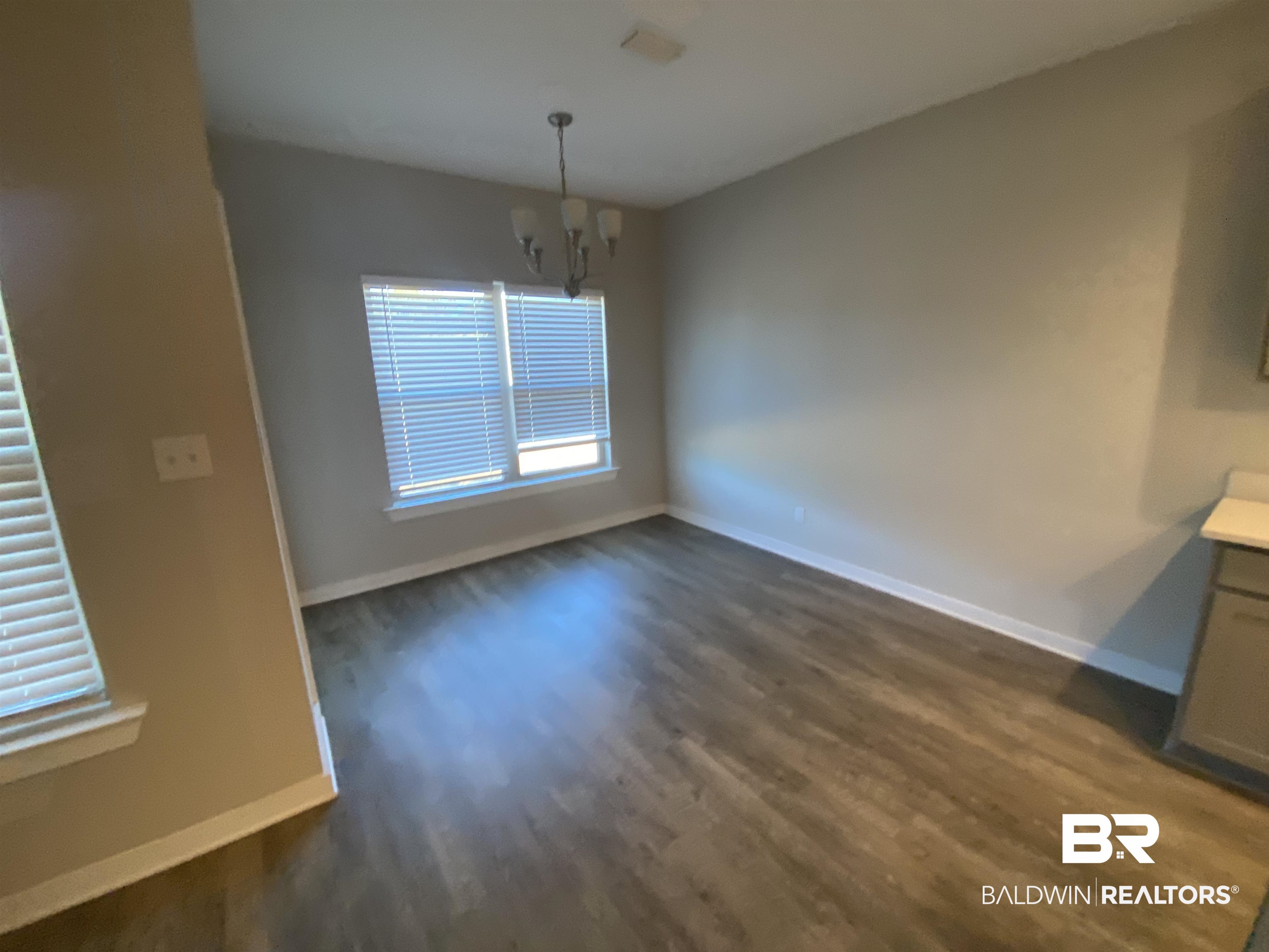 1279 Cater Lee Way Foley, AL 36535 - Photo 9 of 12 Unfurnished dining area with dark hardwood / wood-style flooring and a notable chandelier