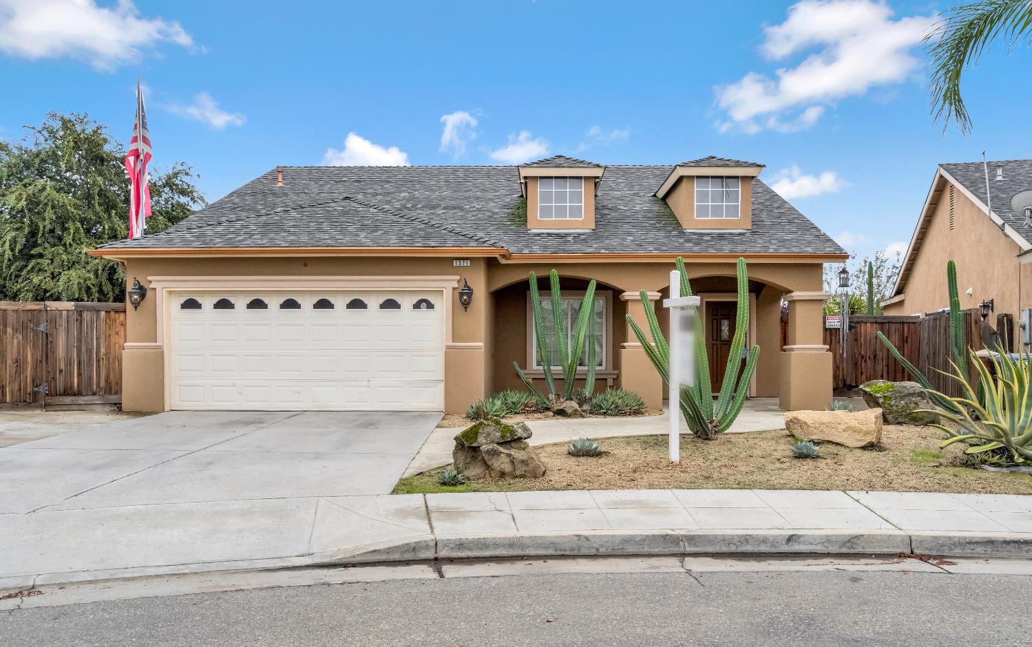 a front view of a house with a garden and parking