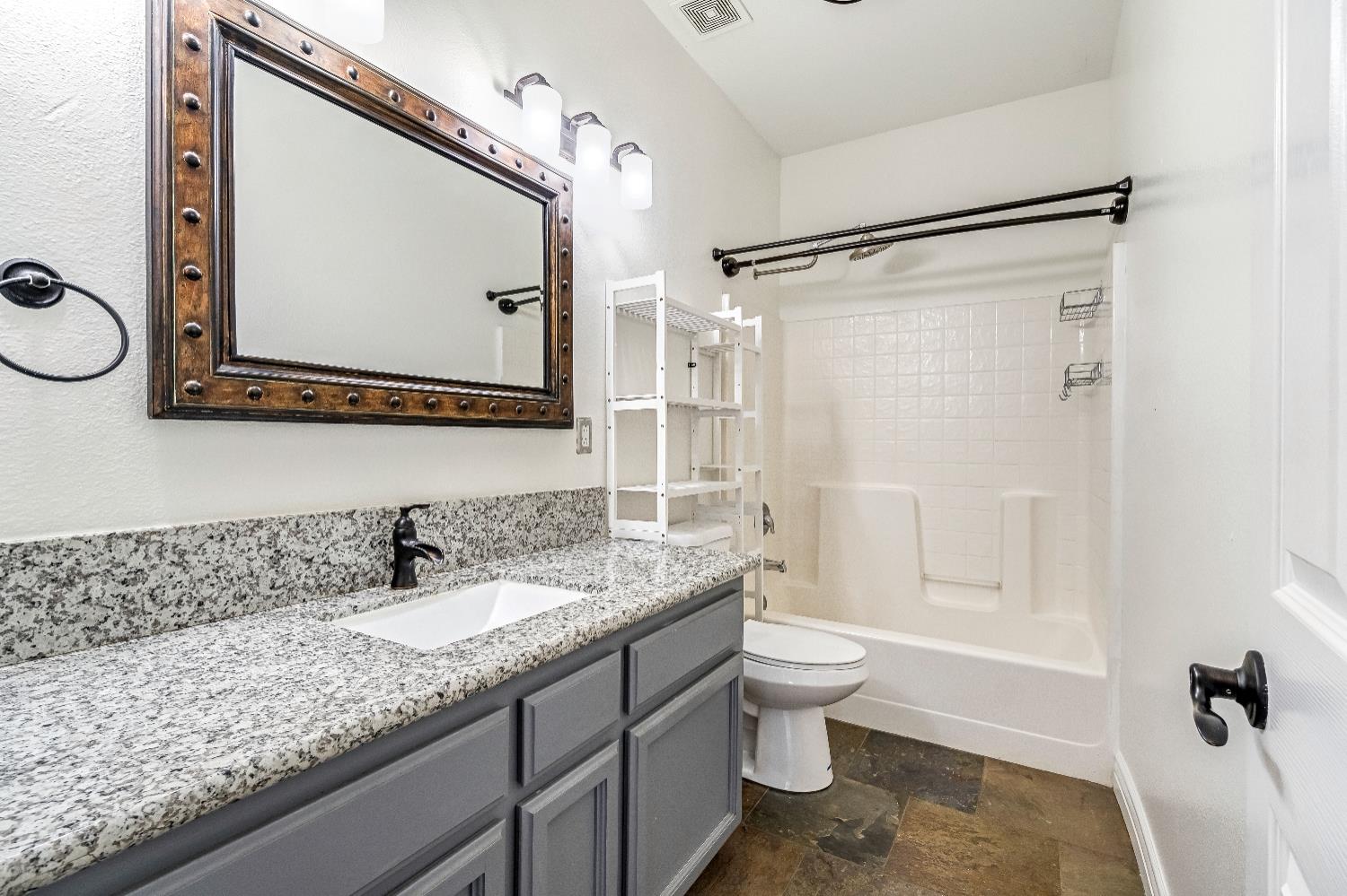 1571 Lemon Avenue Madera, CA 93637 - Photo 17 of 38 a bathroom with a granite countertop sink mirror vanity and toilet