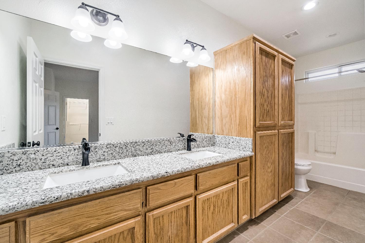 1571 Lemon Avenue Madera, CA 93637 - Photo 26 of 38 a bathroom with a granite countertop sink and a mirror