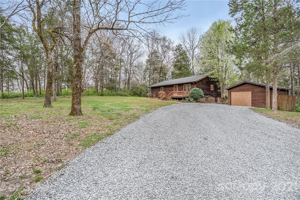 4325 Flowes Store Road Concord, NC 28025 - Photo 3 of 31 a view of a house with a yard and large trees