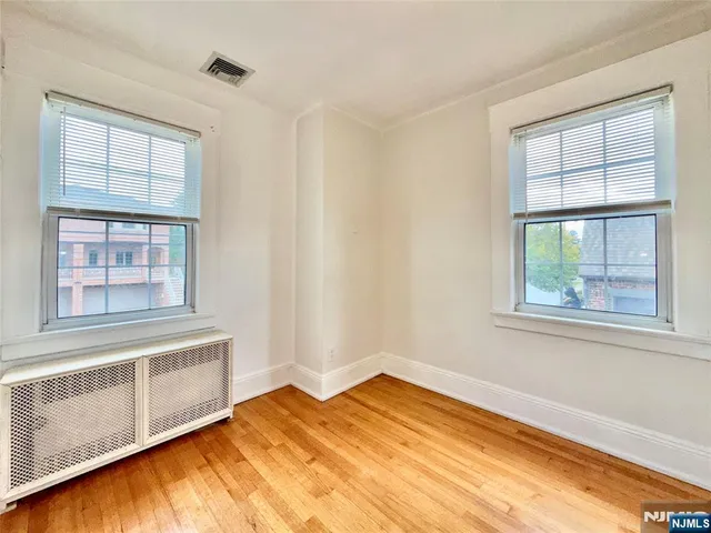 a view of a bedroom with wooden floor and a window