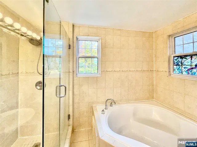 a bathroom with a tub a window and a shower