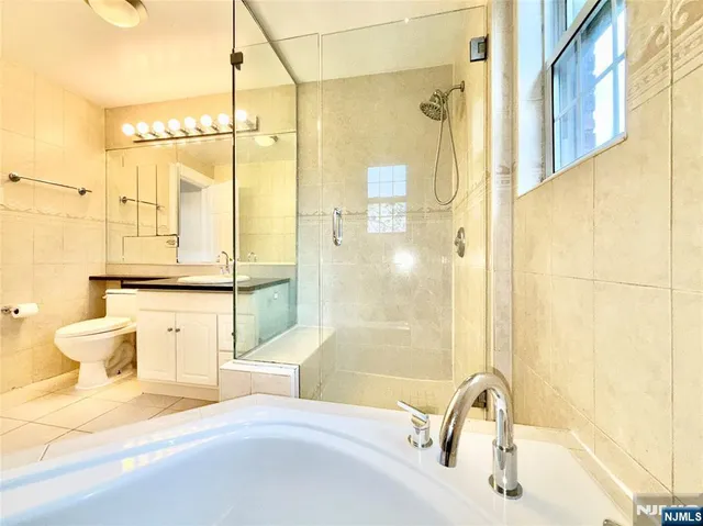 a bathroom with a bathtub shower sink and mirror