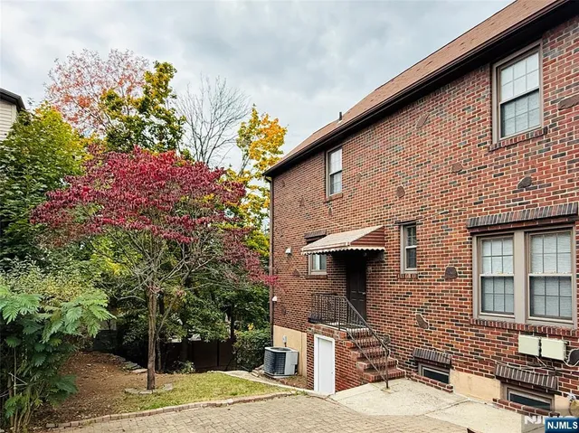 a front view of a house with a tree