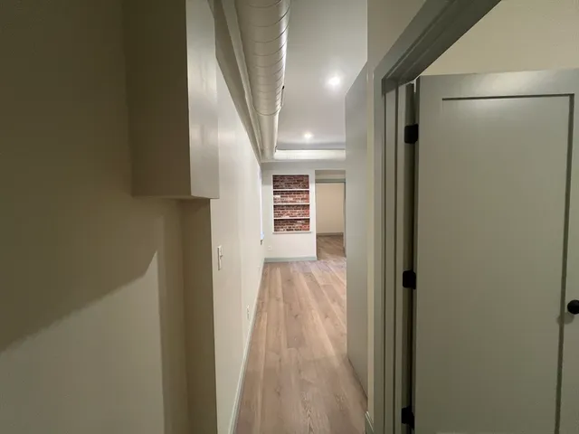 a view of a hallway with wooden floor and staircase