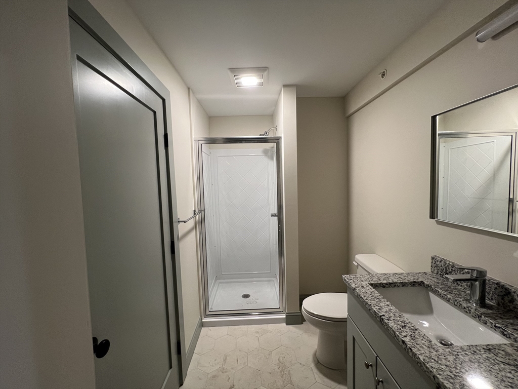 160 Seabury Street, Unit 6 Fall River, MA 02720 - Photo 9 of 10 a bathroom with a granite countertop sink toilet and shower