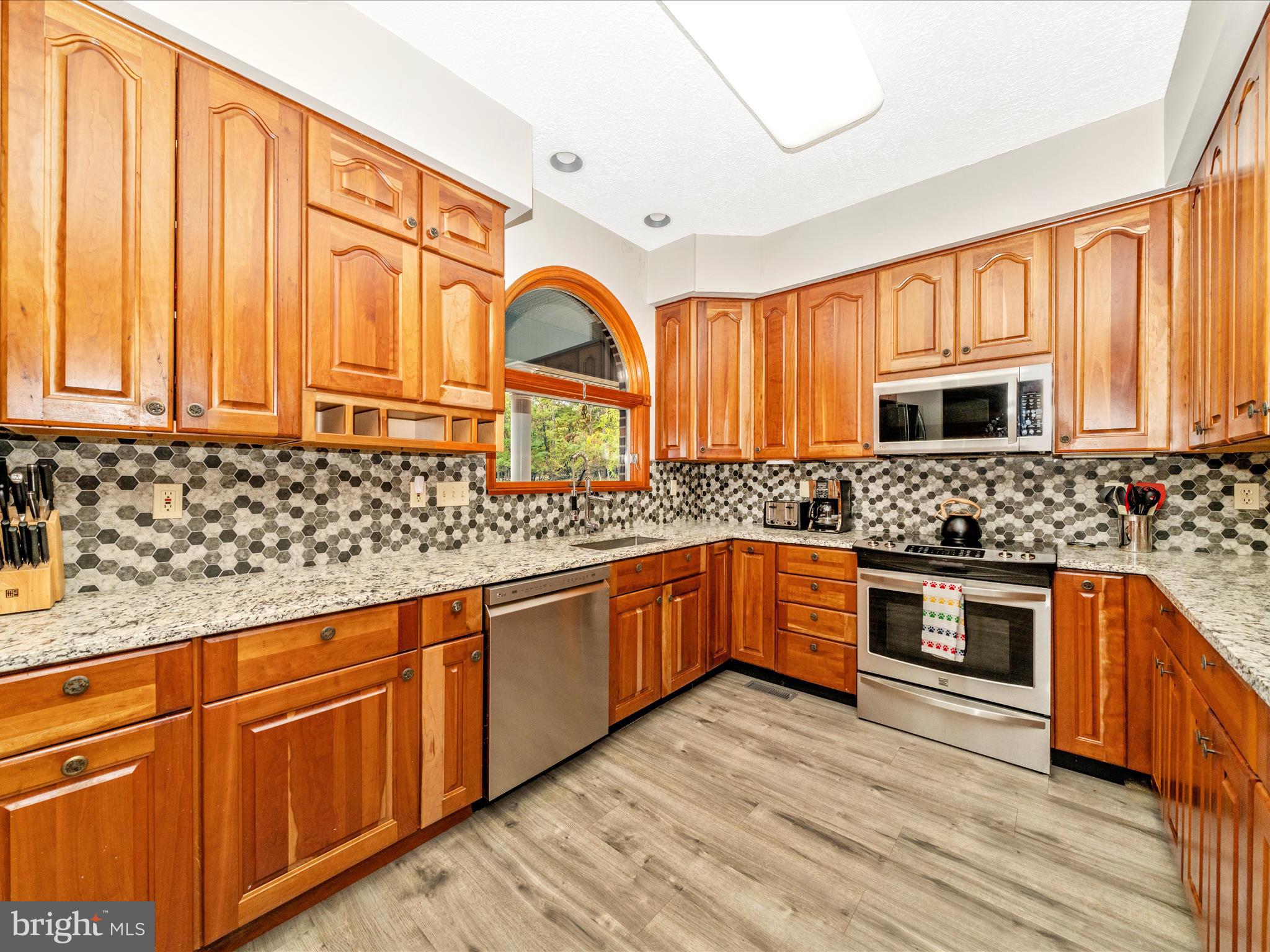 17879 Harbaugh Valley Road Sabillasville, MD 21780 - Photo 11 of 64 a kitchen with stainless steel appliances granite countertop wooden cabinets a sink and a stove
