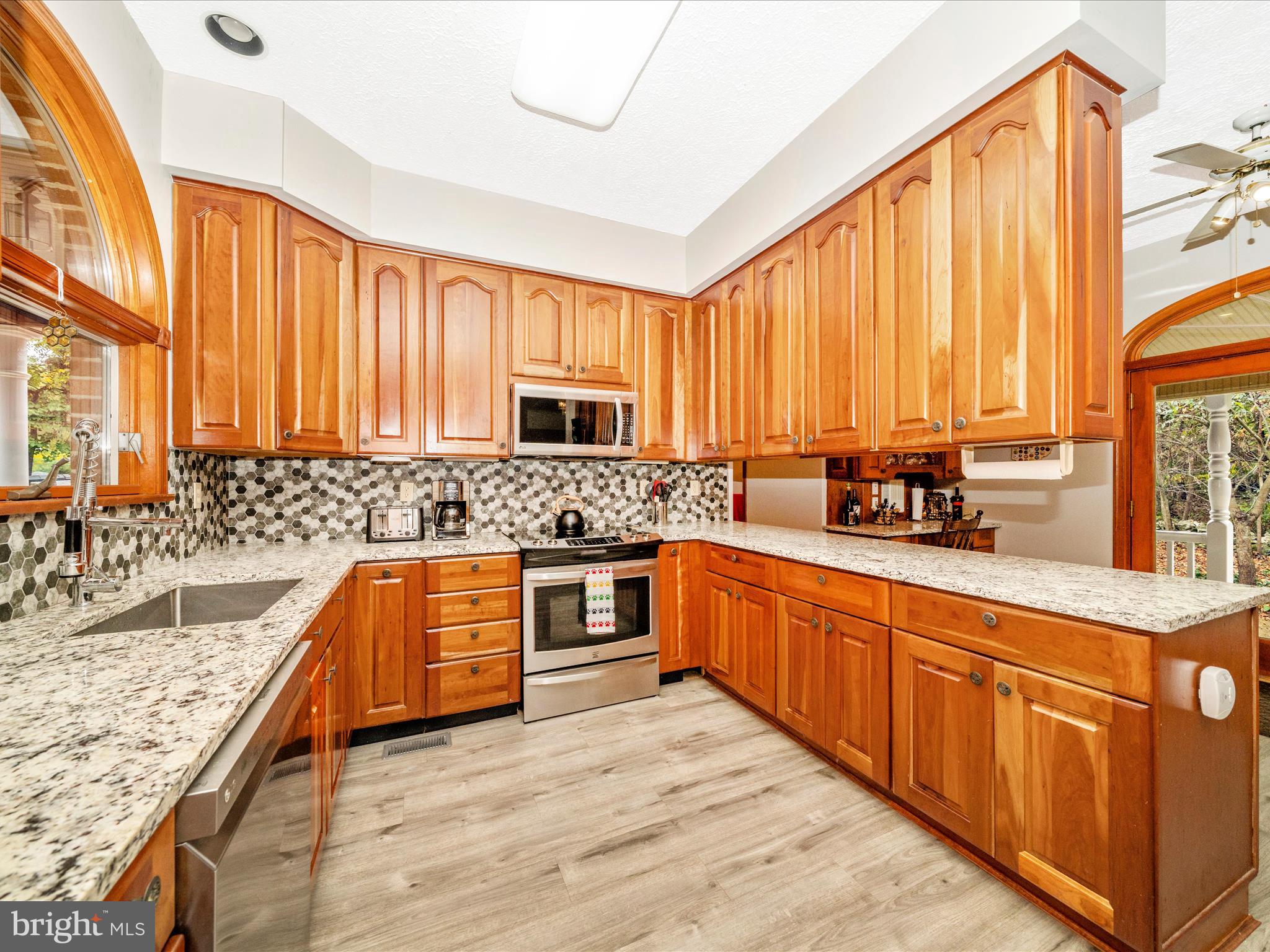 17879 Harbaugh Valley Road Sabillasville, MD 21780 - Photo 12 of 64 a large kitchen with stainless steel appliances granite countertop a sink counter space cabinets and a large window