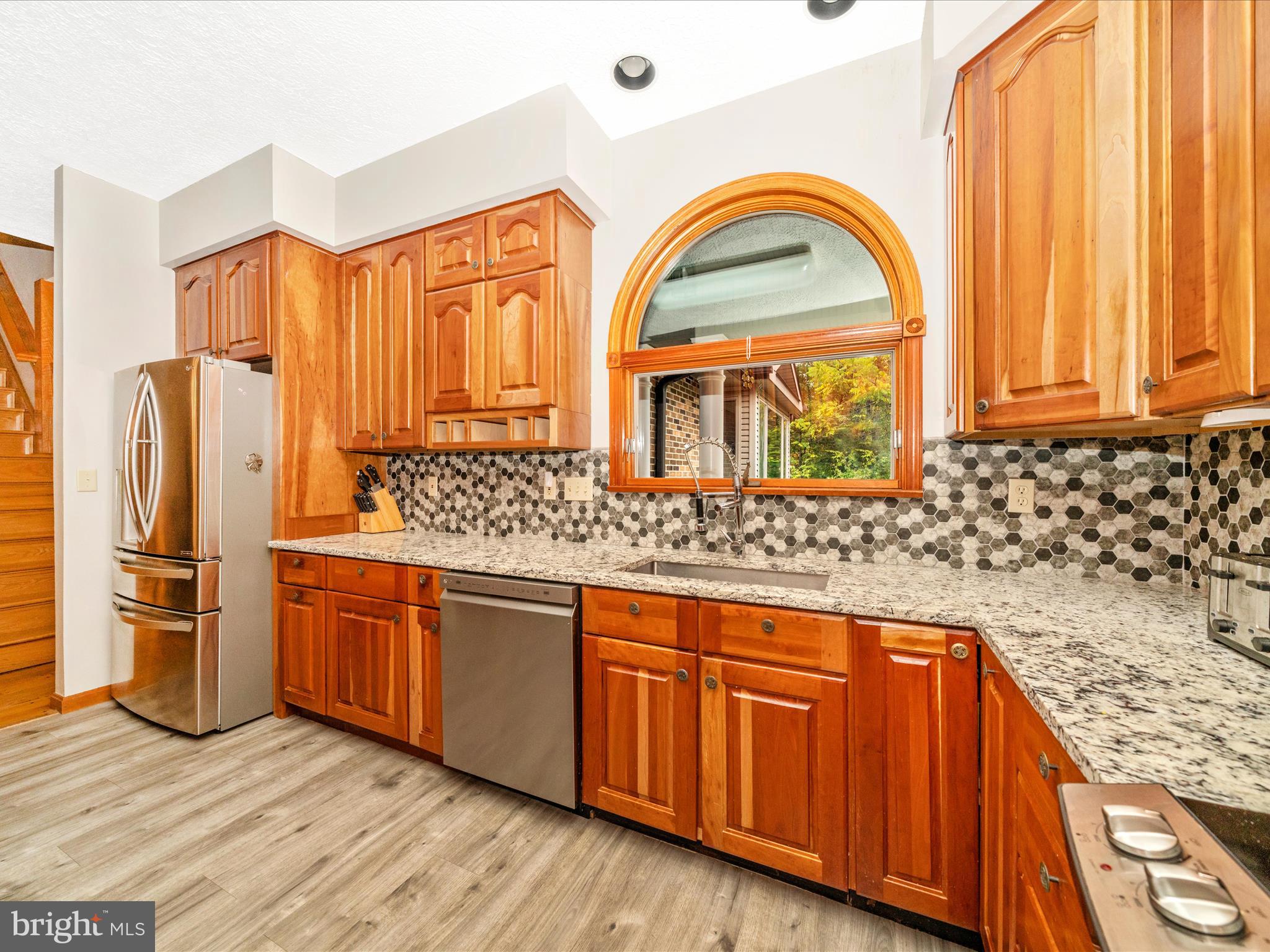 17879 Harbaugh Valley Road Sabillasville, MD 21780 - Photo 13 of 64 a kitchen with stainless steel appliances granite countertop a stove and a wooden cabinets