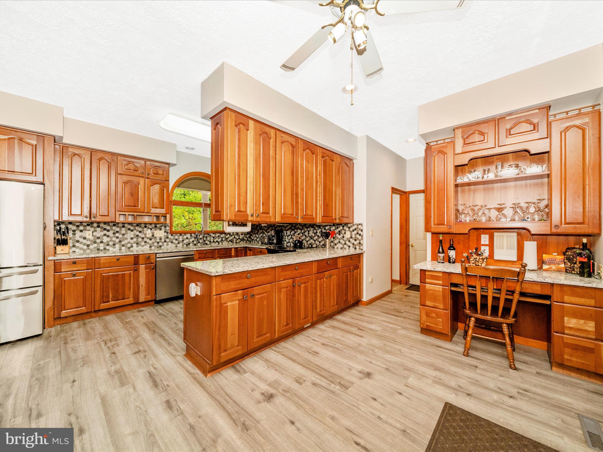 17879 Harbaugh Valley Road Sabillasville, MD 21780 - Photo 14 of 64 a large kitchen with stainless steel appliances a stove a sink dishwasher and a dining table with wooden floor