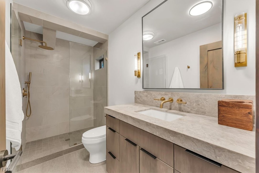 877 Tyner Way Incline Village, NV 89451 - Photo 18 of 43 a bathroom with a granite countertop sink a toilet and a large mirror