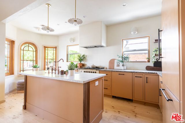 a kitchen with stainless steel appliances kitchen island granite countertop a sink and a stove