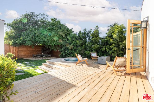 a vase of flowers sitting on a floor in front of a house