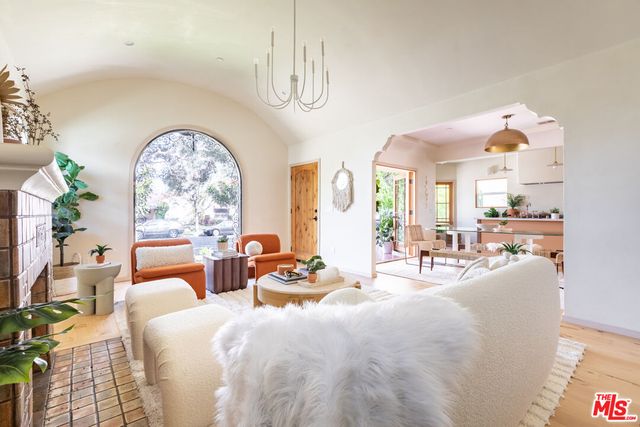 a living room with furniture a fireplace and potted plants