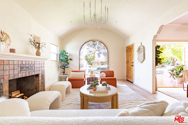 a living room with furniture potted plant and a large mirror