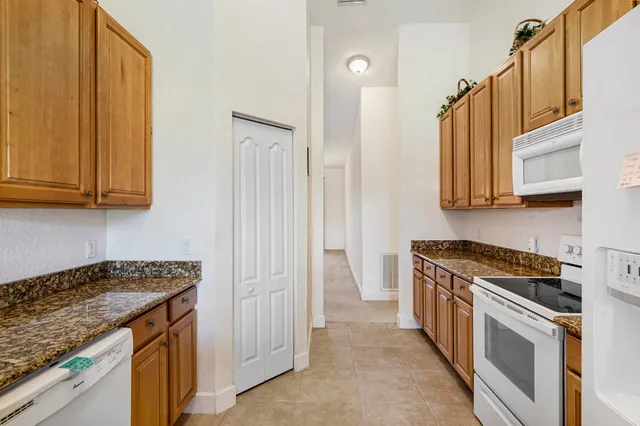 a view of a dining room with furniture a potted plant and wooden floor