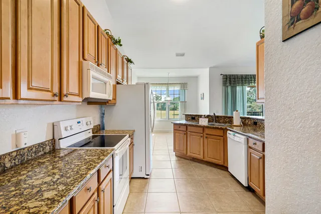 a kitchen with stainless steel appliances granite countertop a stove and more cabinets