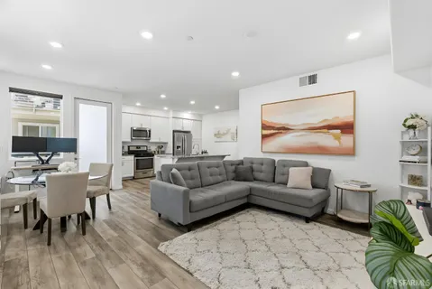a living room with furniture kitchen view and a table