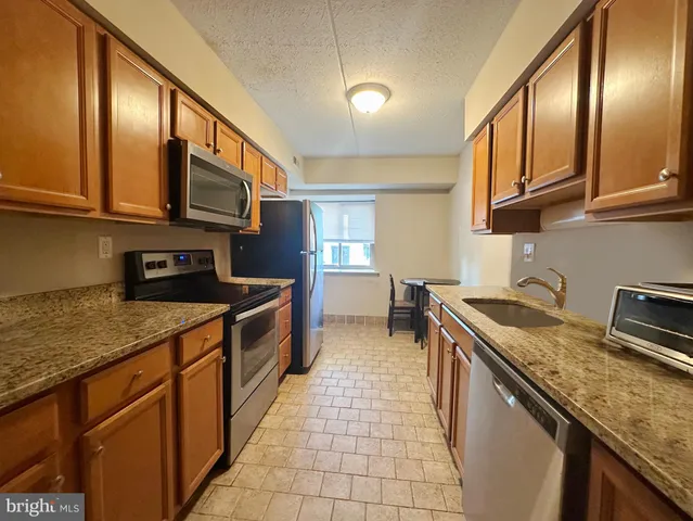 a kitchen with stainless steel appliances granite countertop a sink stove and cabinets