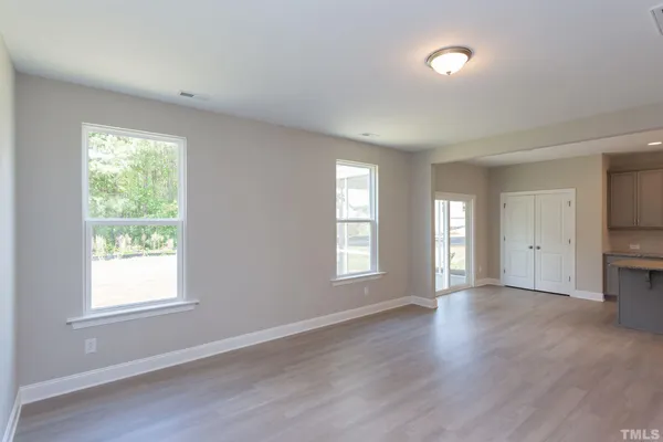 a view of empty room with window and wooden floor