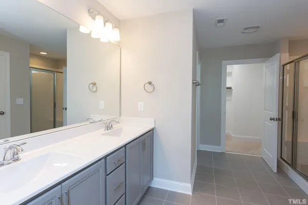 a bathroom with a sink vanity granite tub shower and a mirror