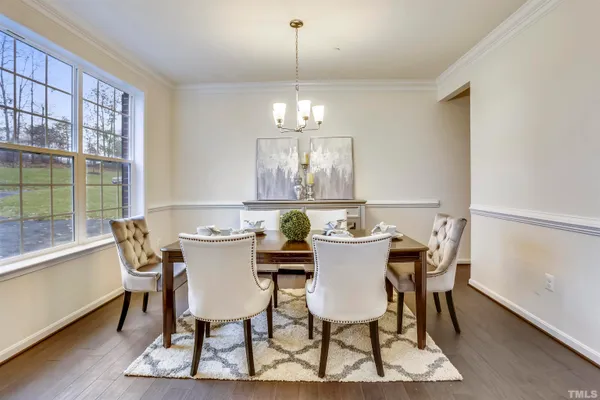 a view of a dining room with furniture a chandelier and wooden floor