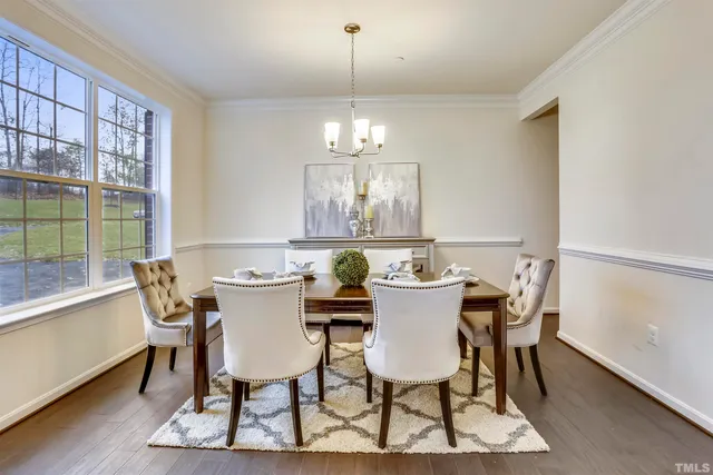 a view of a dining room with furniture a chandelier and wooden floor