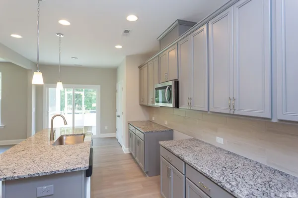 a kitchen with stainless steel appliances granite countertop a sink a oven and a refrigerator