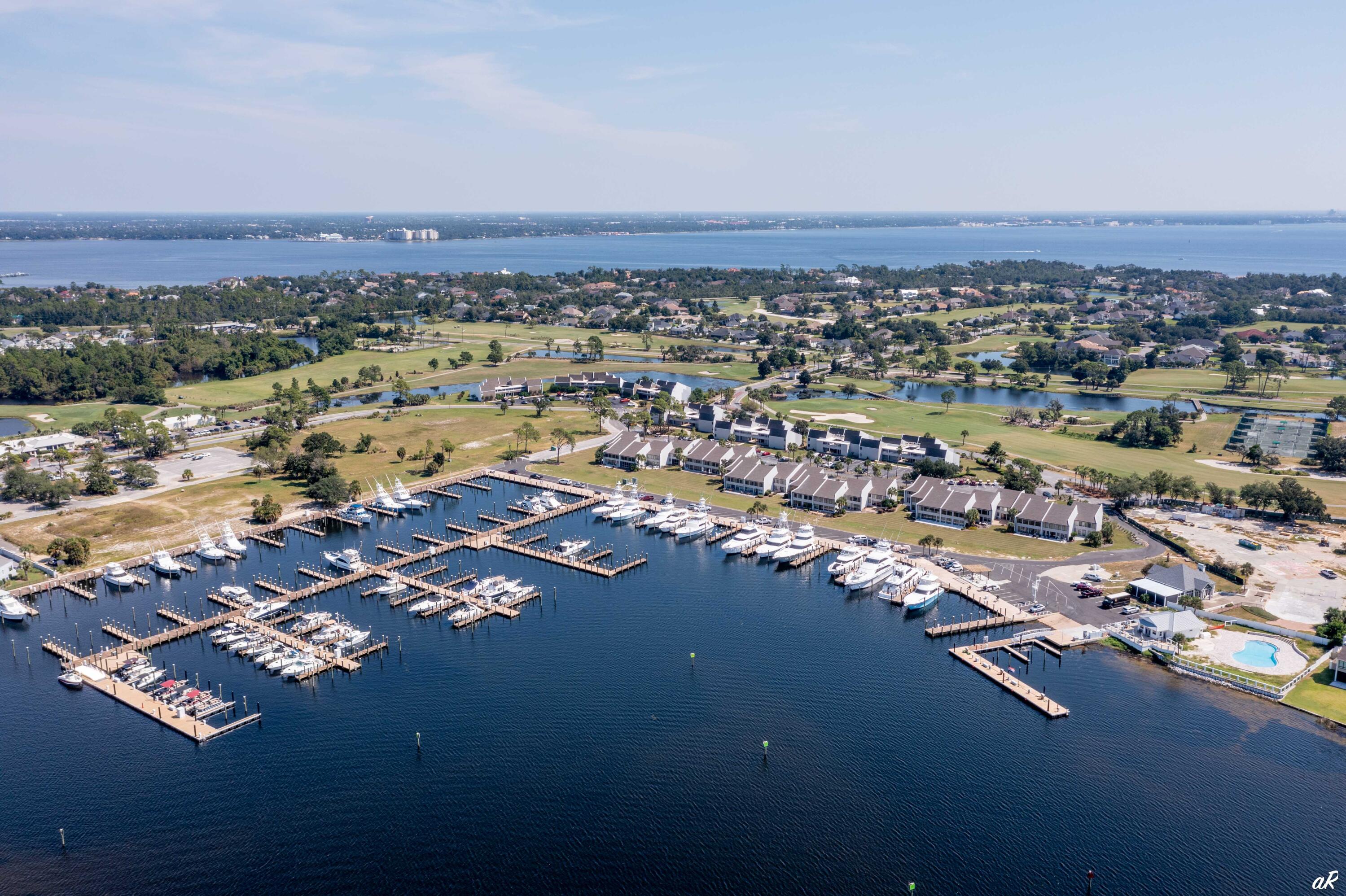 4300 Bay Point Road, Unit 417 Panama City Beach, FL 32408 - Photo 1 of 35 an aerial view of a city with lots of residential buildings and mountain view in back