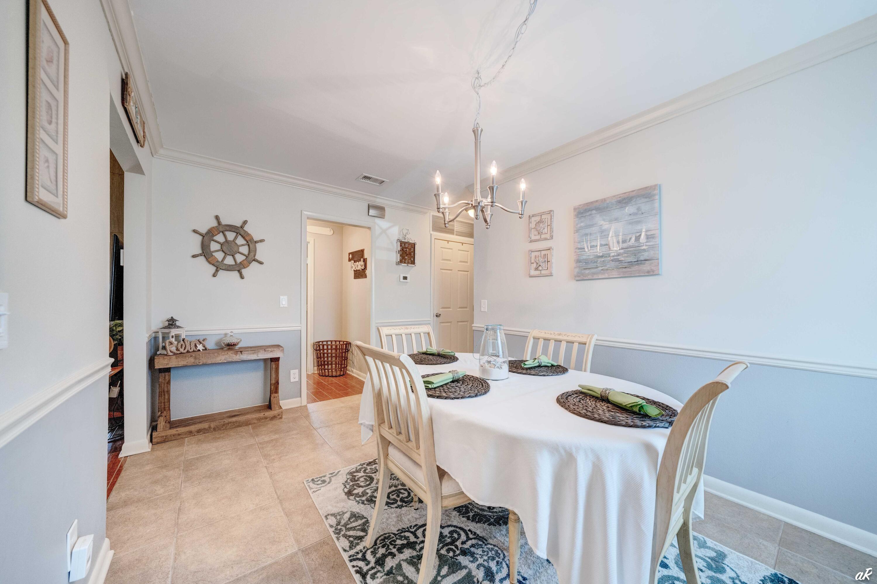 4300 Bay Point Road, Unit 417 Panama City Beach, FL 32408 - Photo 11 of 35 a dining room with furniture and chandelier