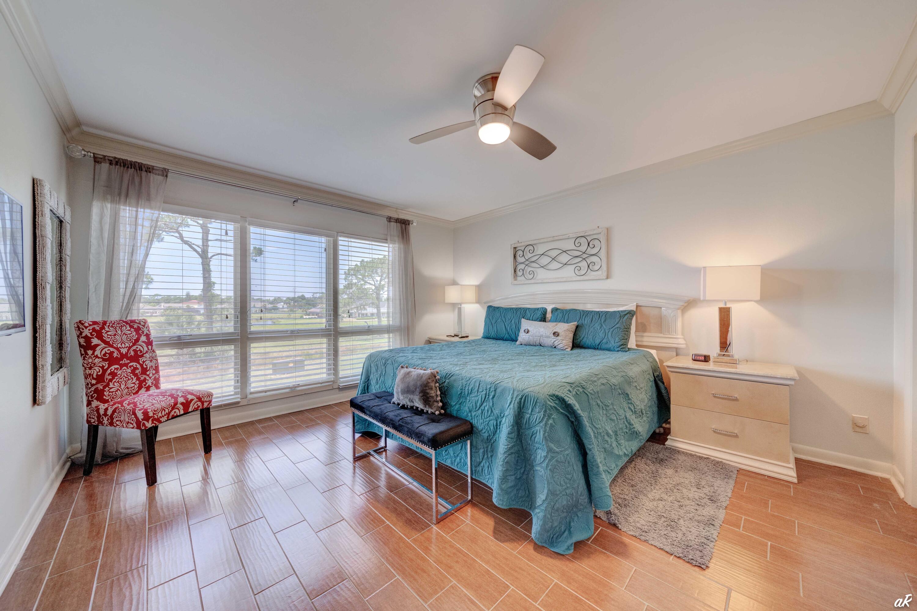4300 Bay Point Road, Unit 417 Panama City Beach, FL 32408 - Photo 12 of 35 a spacious bedroom with a bed a couch and a window