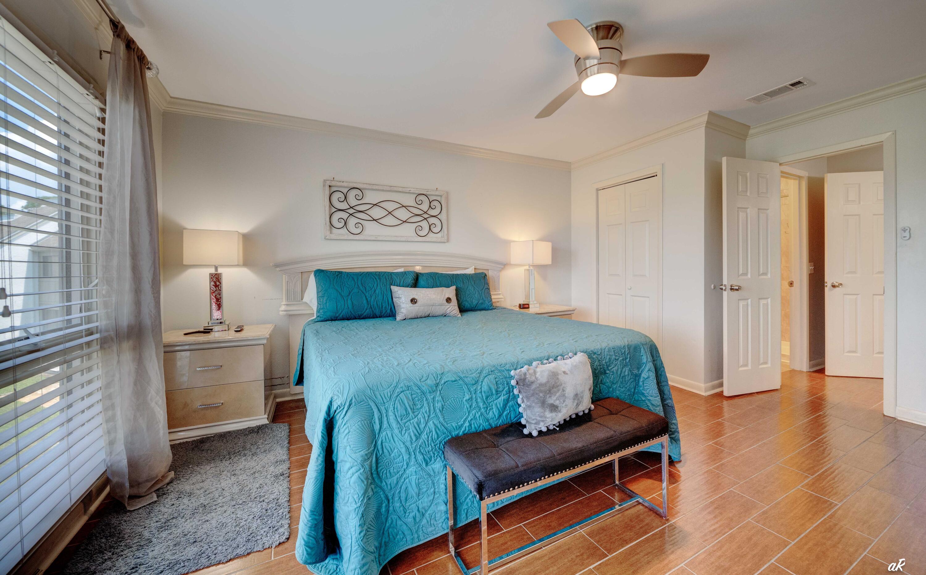 4300 Bay Point Road, Unit 417 Panama City Beach, FL 32408 - Photo 13 of 35 a bedroom with a bed and a chandelier