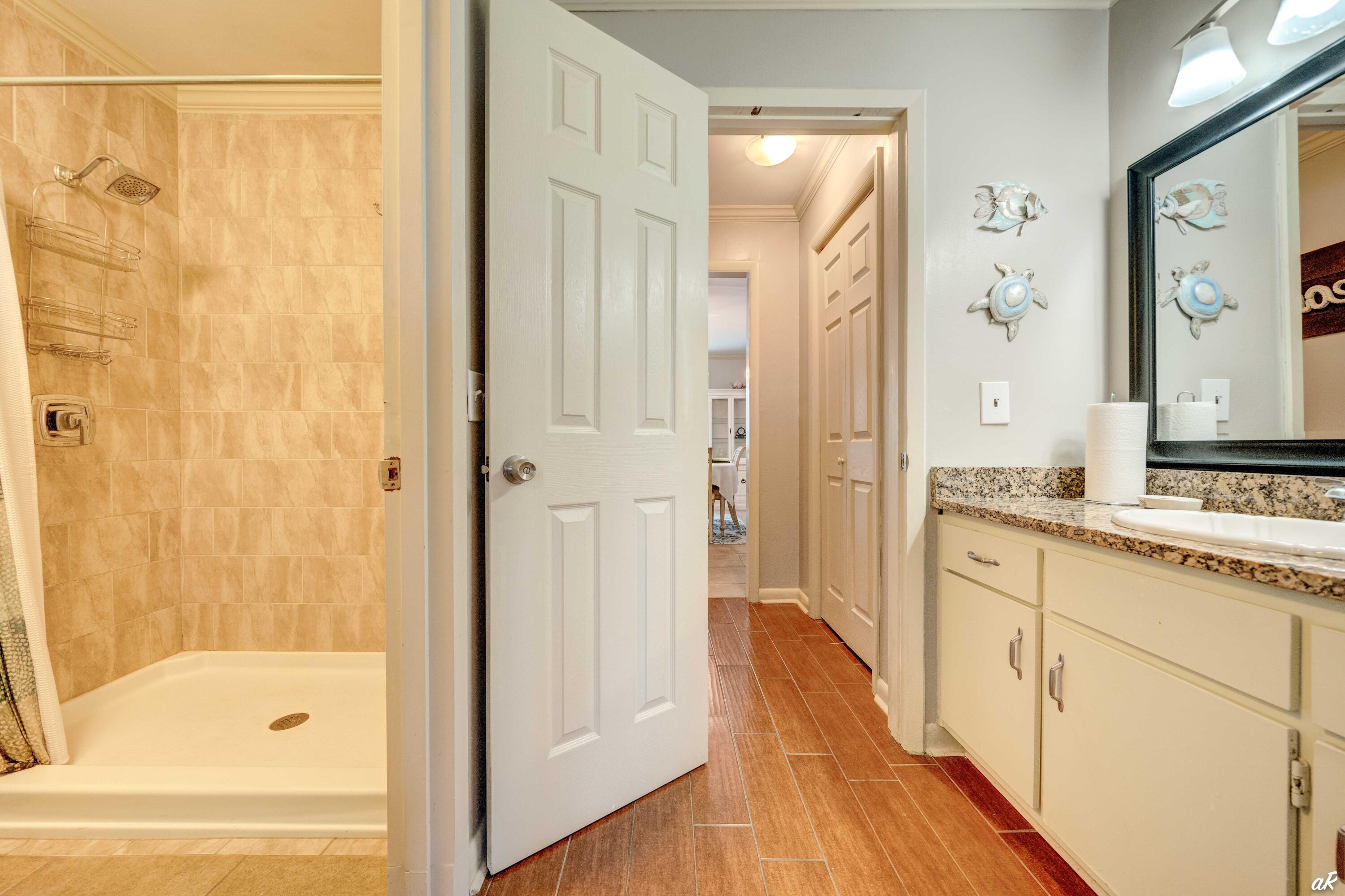 4300 Bay Point Road, Unit 417 Panama City Beach, FL 32408 - Photo 16 of 35 a bathroom with a granite countertop sink a mirror a bathtub and shower