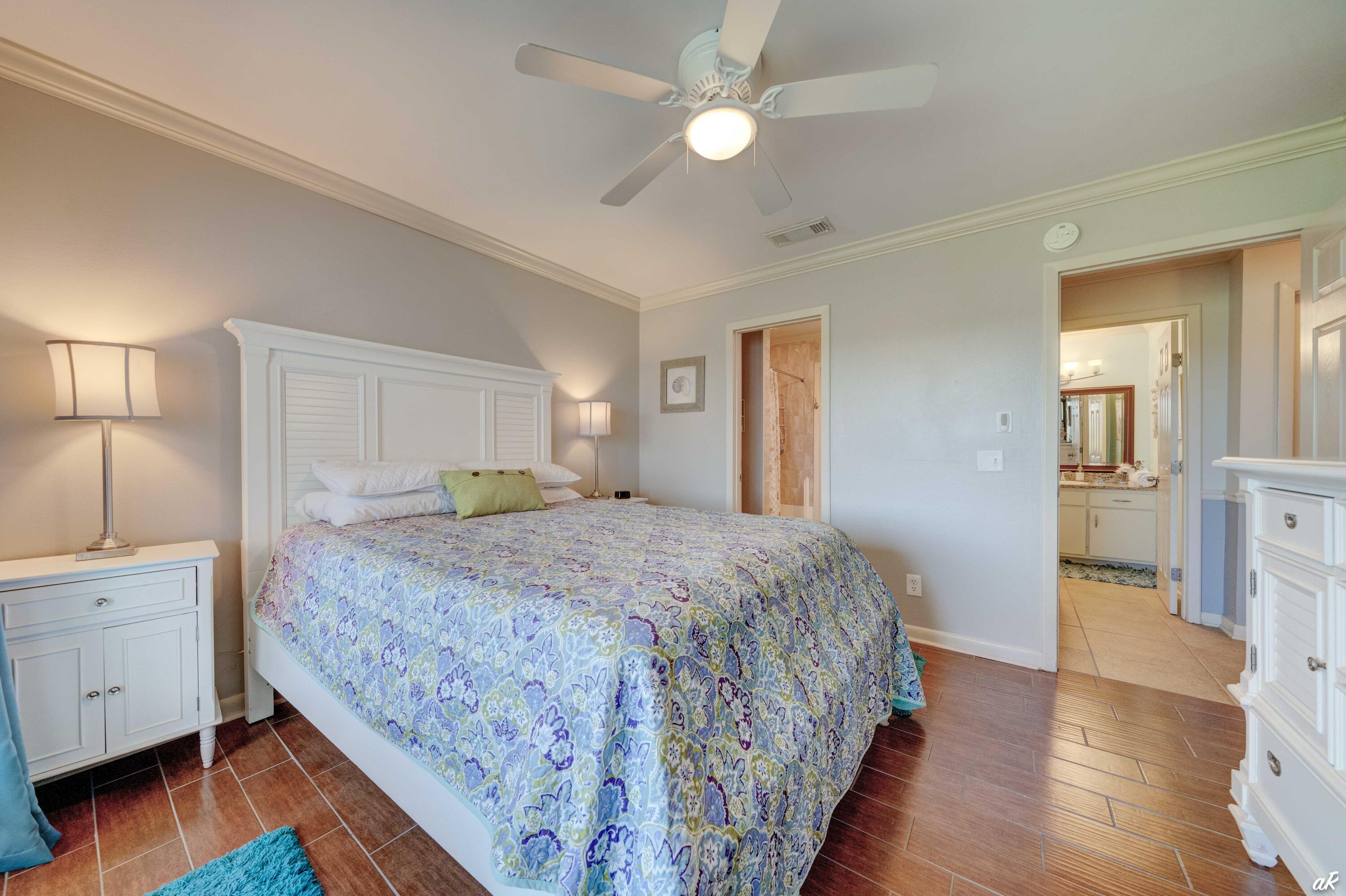 4300 Bay Point Road, Unit 417 Panama City Beach, FL 32408 - Photo 18 of 35 a spacious bedroom with a bed and wooden floor