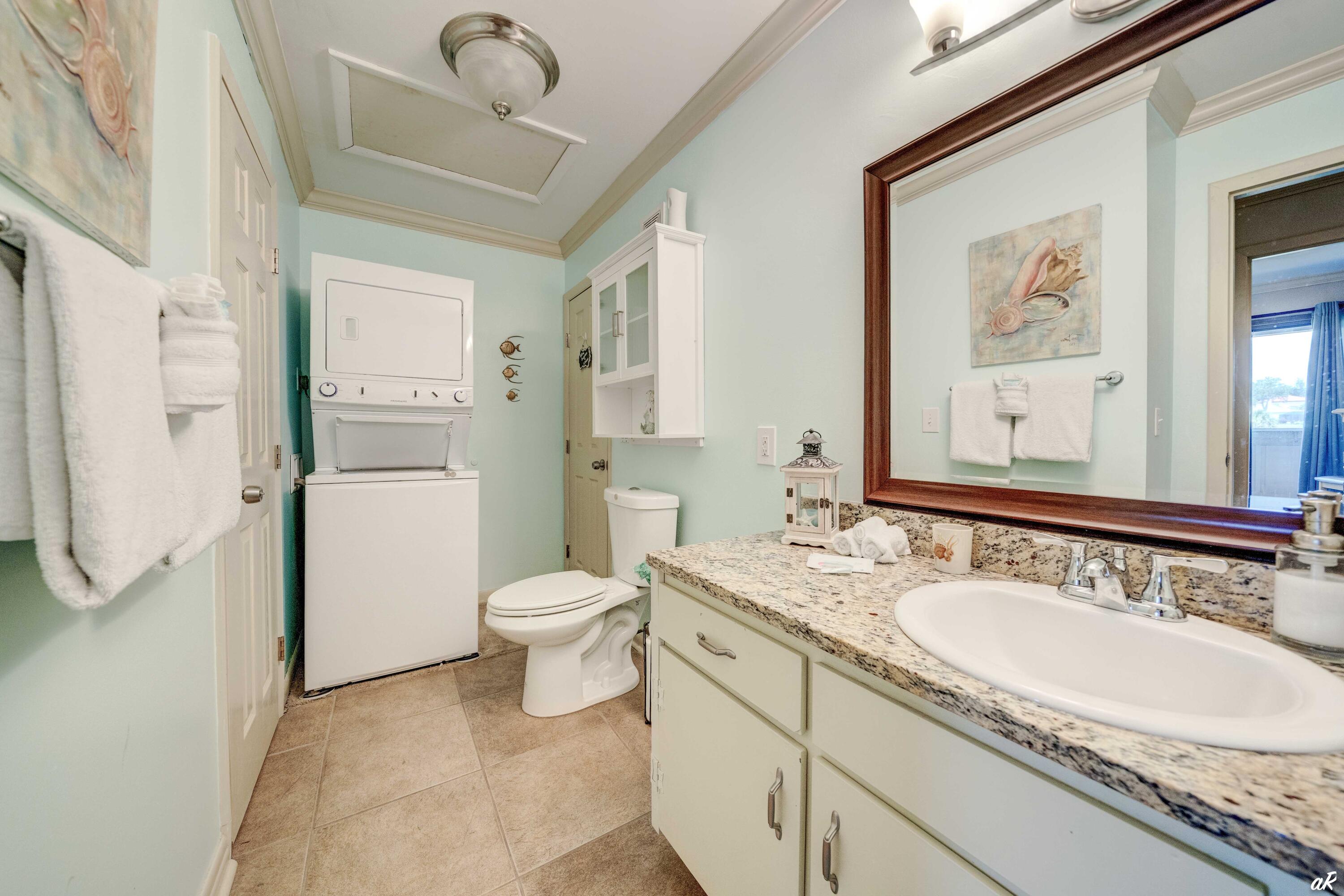 4300 Bay Point Road, Unit 417 Panama City Beach, FL 32408 - Photo 20 of 35 a bathroom with a granite countertop sink mirror vanity and toilet