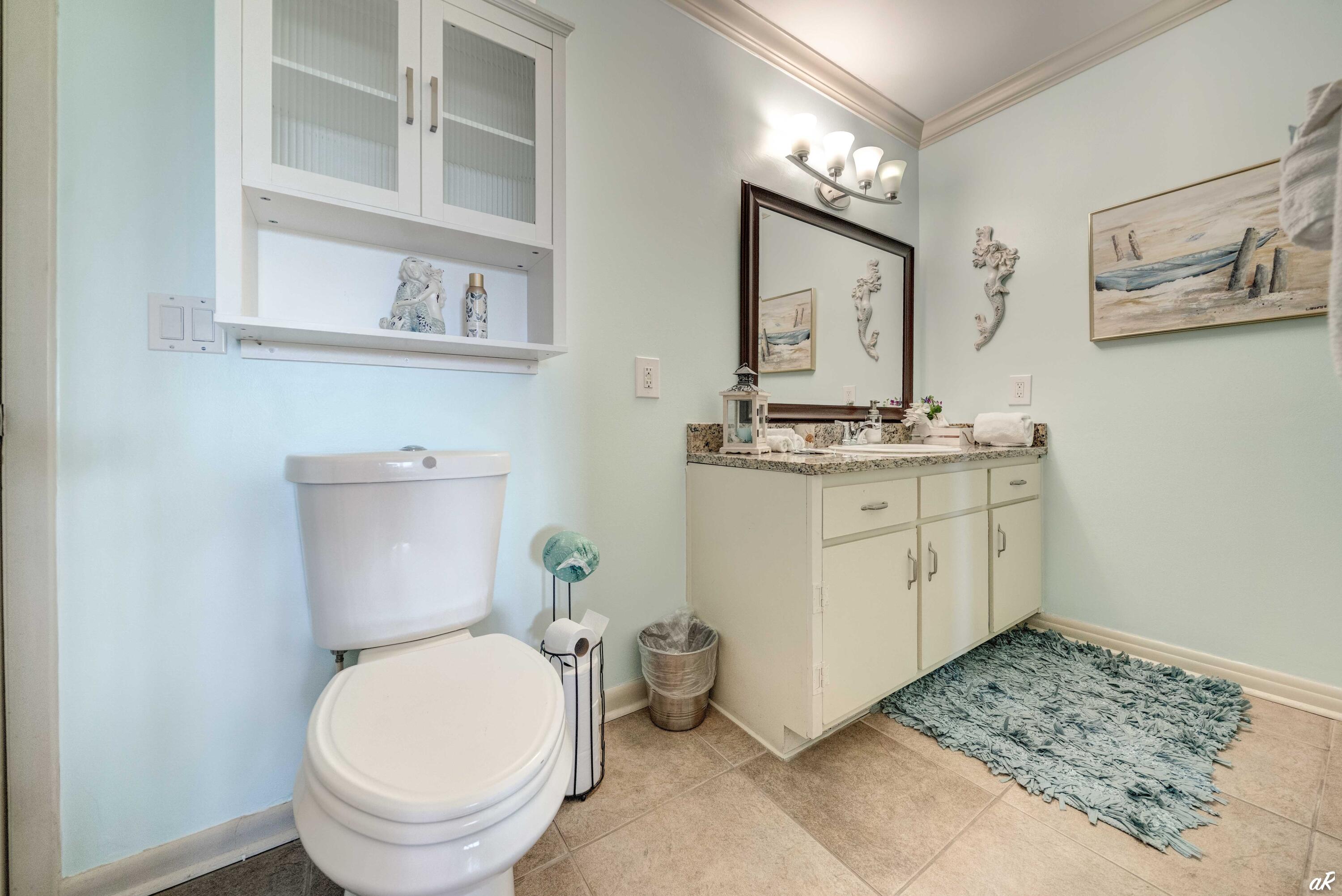 4300 Bay Point Road, Unit 417 Panama City Beach, FL 32408 - Photo 21 of 35 a bathroom with a granite countertop toilet sink and mirror