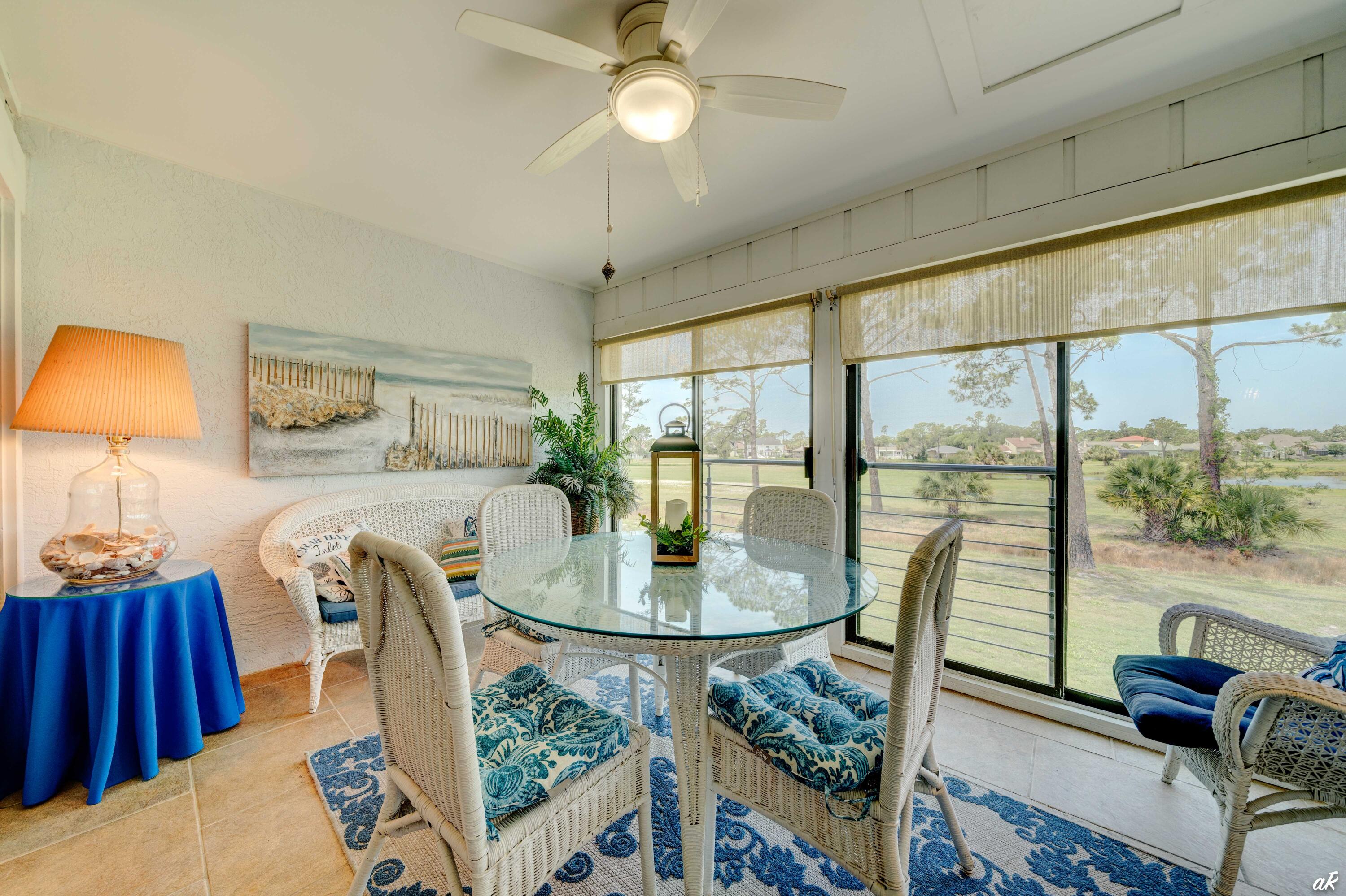 4300 Bay Point Road, Unit 417 Panama City Beach, FL 32408 - Photo 25 of 35 a dining room with furniture a chandelier and wooden floor