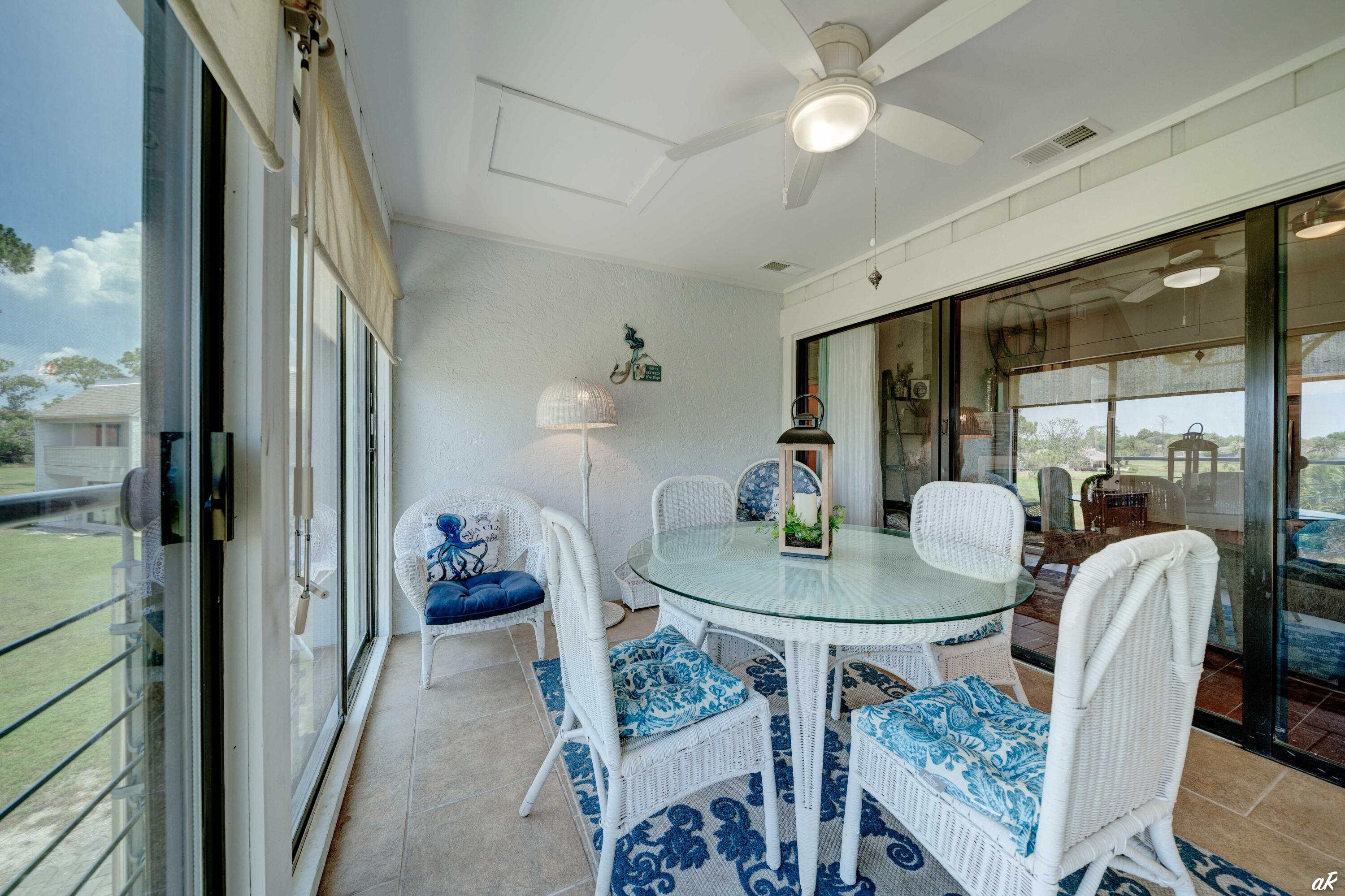 4300 Bay Point Road, Unit 417 Panama City Beach, FL 32408 - Photo 27 of 35 a dining room with furniture and a floor to ceiling window